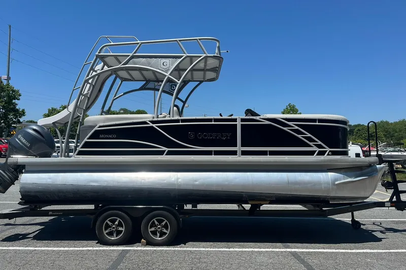 The Image of 2023 Godfrey Monaco 235 SD pontoon boat on trailer, featuring Yamaha outboard motor. - 0