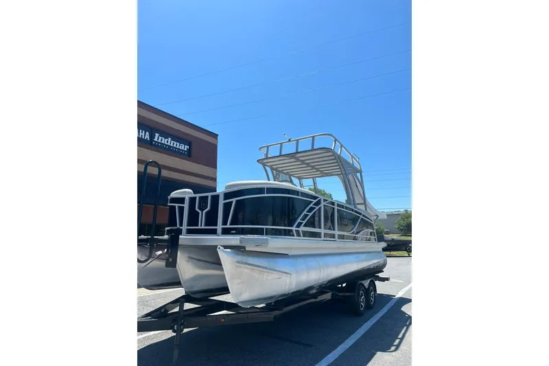 Slide: The Image of 2023 Godfrey Monaco 235 SD pontoon boat on trailer under clear blue sky. - 2