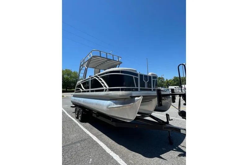 Slide: The Image of 2023 Godfrey Monaco 235 SD pontoon boat on trailer under clear blue sky. - 3