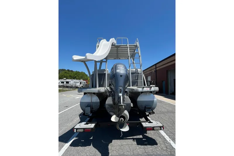 Slide: The Image of 2023 Godfrey Monaco 235 SD boat with slide and outboard motor, parked outdoors. - 4