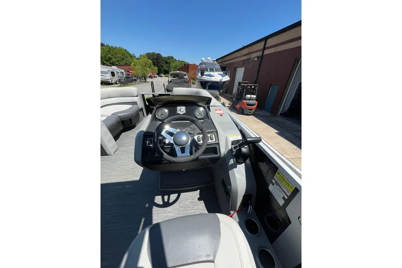 Slide: The Image of 2023 Godfrey Monaco 235 SD boat interior with steering wheel and dashboard controls. - 8