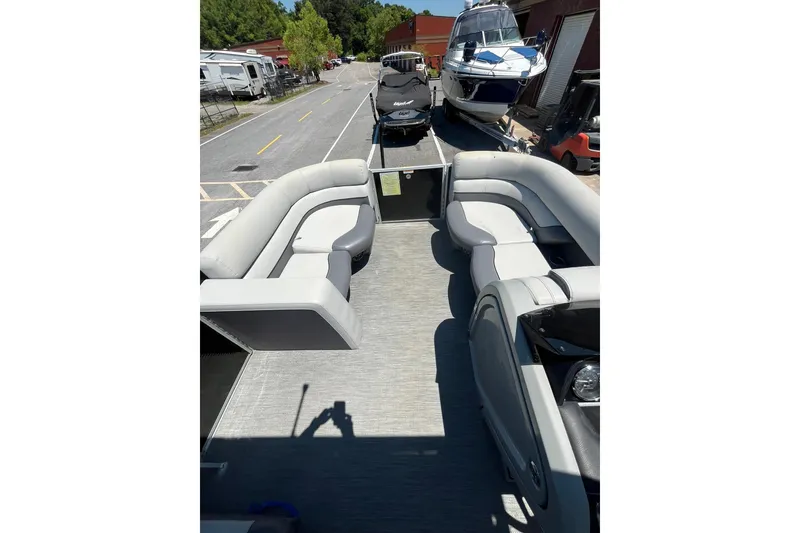 Slide: The Image of 2023 Godfrey Monaco 235 SD pontoon boat with spacious seating, parked near other boats. - 9