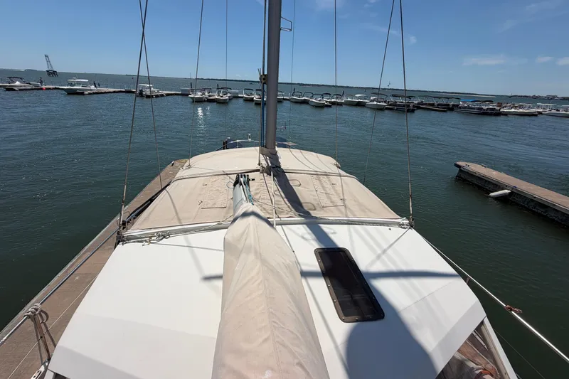 Slide: The Image of Sailboat Amel Mango 52, 1980 model, docked at a marina under clear blue skies. - 22