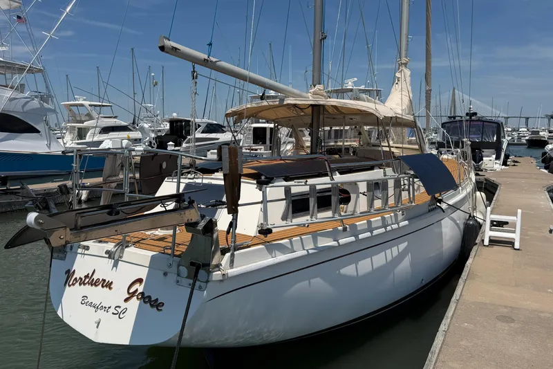 Slide: The Image of 1980 Amel Mango 52 sailboat docked at marina under clear blue sky. - 5