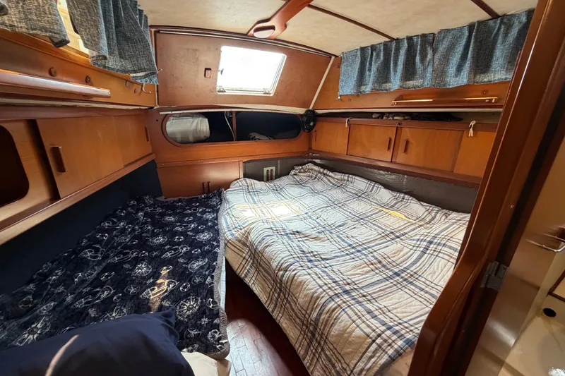 Slide: The Image of Cozy cabin interior of 1980 Amel Mango 52 sailboat with double bed and wooden furnishings. - 47