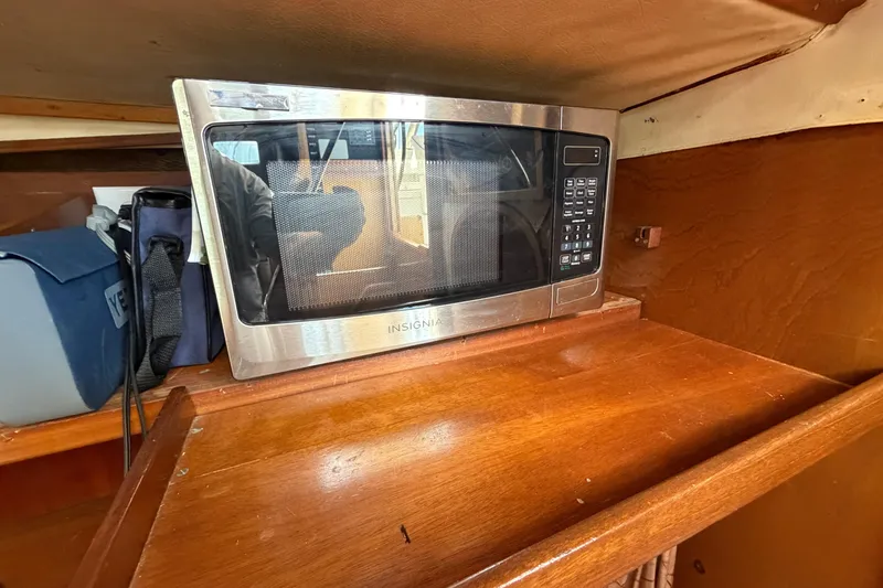 Slide: The Image of Microwave on wooden shelf inside 1980 Amel Mango 52 yacht interior. - 44