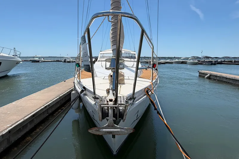 Slide: The Image of 1980 Amel Mango 52 sailboat docked at marina under clear blue sky. - 4