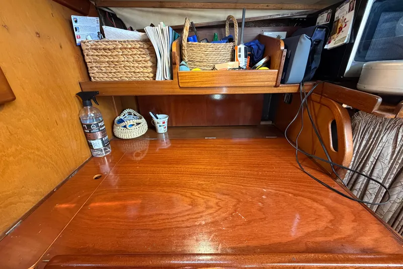 Slide: The Image of Wooden desk area on 1980 Amel Mango 52 yacht with storage baskets and items. - 45