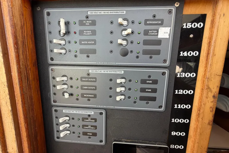 Slide: The Image of Electrical panel of a 1980 Amel Mango 52 sailboat with labeled switches. - 57