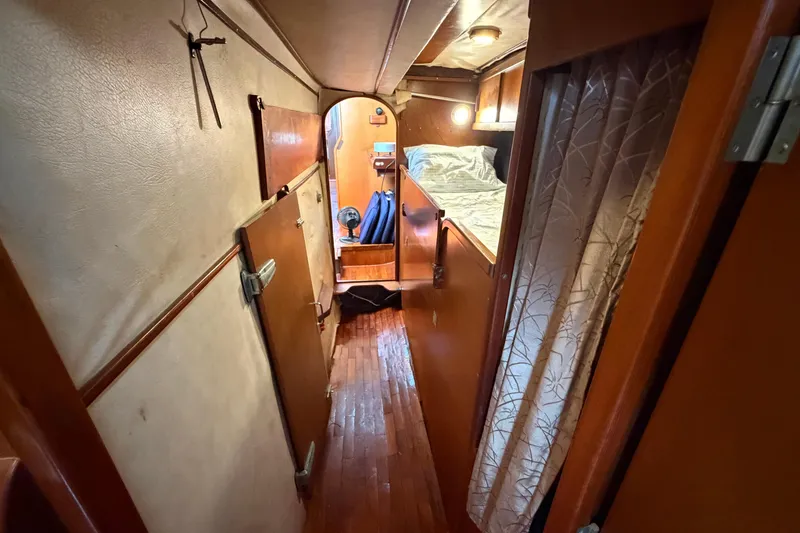 Slide: The Image of Narrow hallway inside 1980 Amel Mango 52 yacht, featuring wooden flooring and cozy cabin. - 51