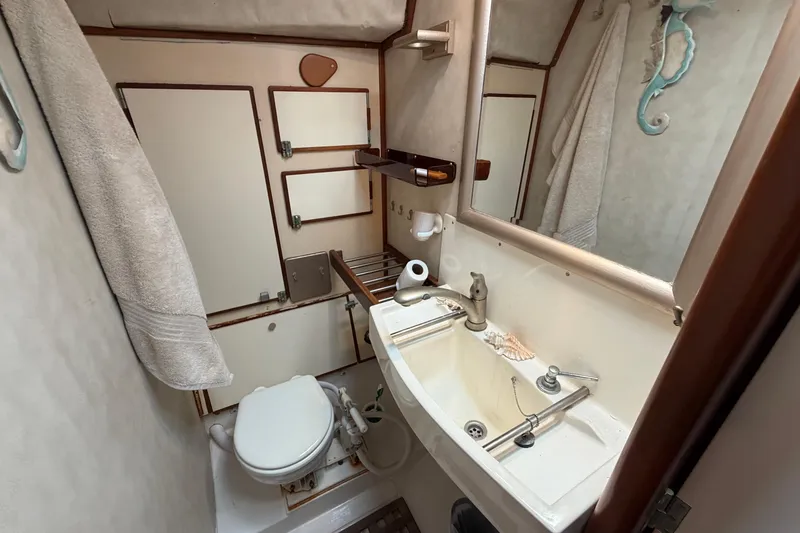 Slide: The Image of Compact bathroom in 1980 Amel Mango 52 yacht with sink, toilet, and mirror. - 56