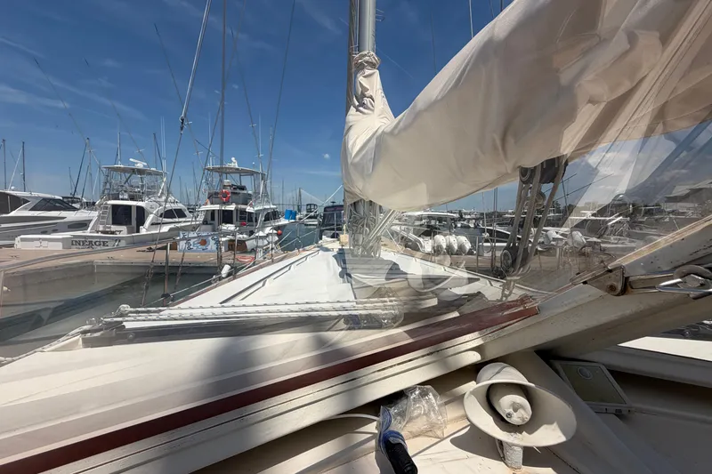 Slide: The Image of 1980 Amel Mango 52 sailboat docked in a marina, surrounded by other boats. - 32