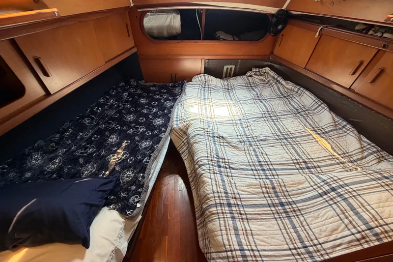 Slide: The Image of Cozy cabin interior of 1980 Amel Mango 52 sailboat with twin beds and wooden cabinetry. - 48