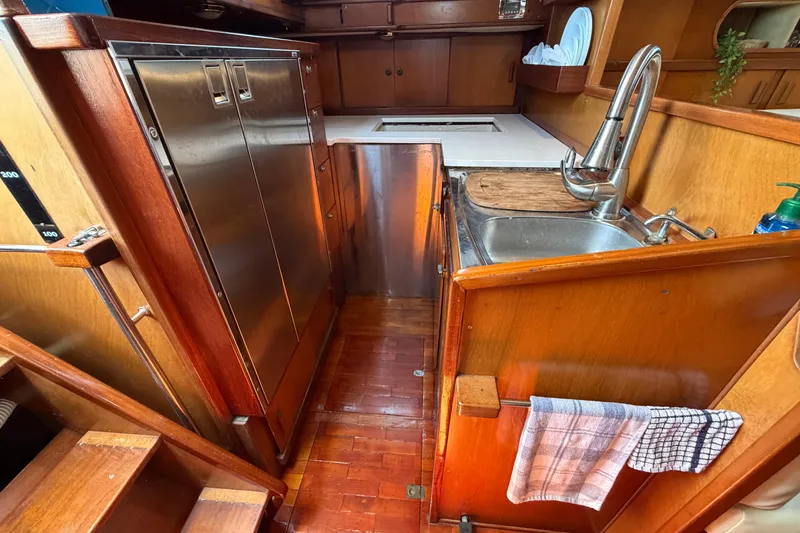Slide: The Image of Galley kitchen in 1980 Amel Mango 52 yacht with wooden cabinetry and stainless steel sink. - 41