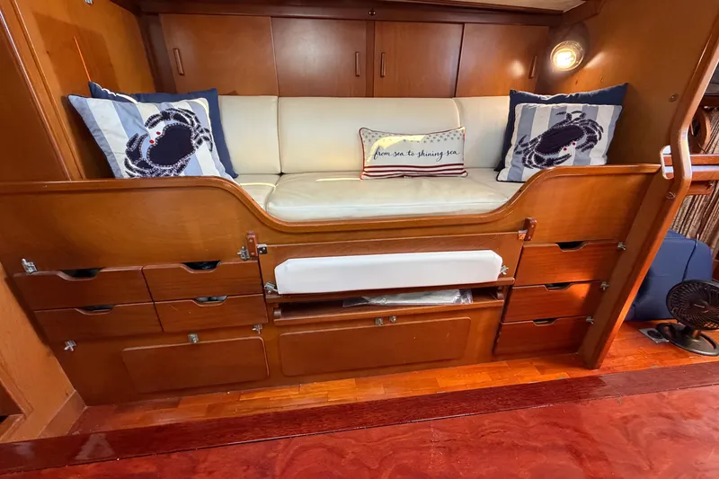 Slide: The Image of Interior of 1980 Amel Mango 52 yacht with cushioned seating and nautical-themed pillows. - 40