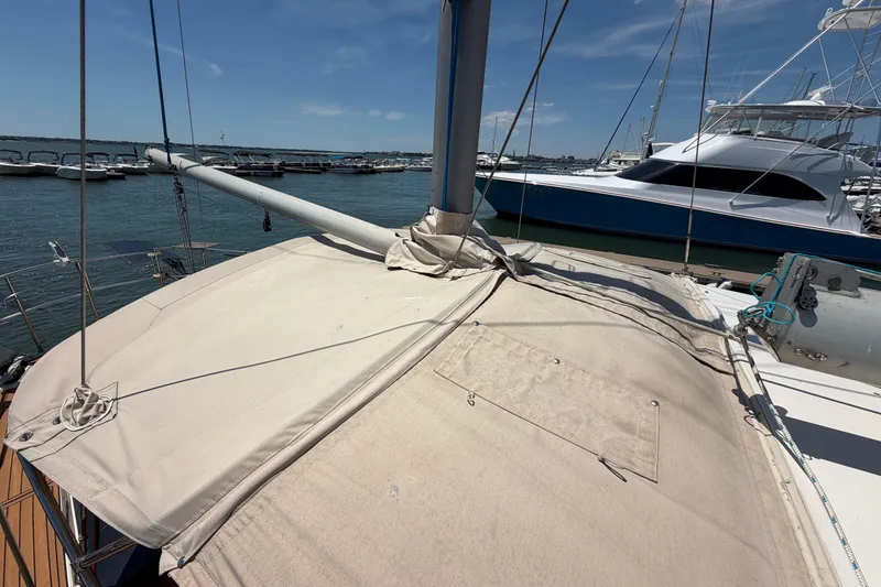 Slide: The Image of 1980 Amel Mango 52 sailboat docked at marina under clear blue sky. - 23
