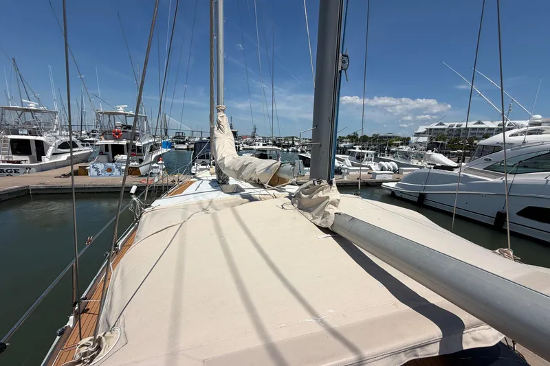 Slide: The Image of 1980 Amel Mango 52 sailboat docked in a marina under clear blue skies. - 26