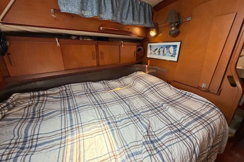 Slide: The Image of Cozy cabin interior of 1980 Amel Mango 52 sailboat with plaid bedding and wooden cabinetry. - 49