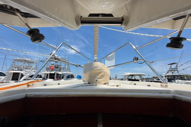 Slide: The Image of 1980 Amel Mango 52 sailboat deck view in marina, clear blue sky background. - 55