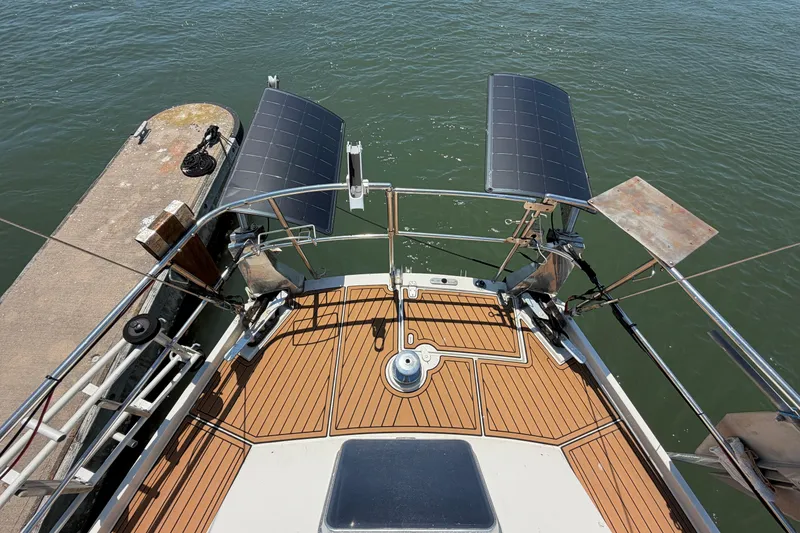 Slide: The Image of Deck view of 1980 Amel Mango 52 sailboat with solar panels and wooden flooring. - 24