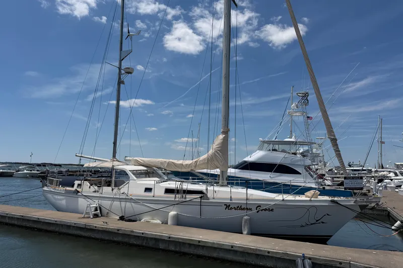 Slide: The Image of Sailboat "Northern Goose," Amel Mango 52, 1980, docked at marina under blue sky. - 6
