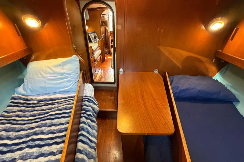 Slide: The Image of Cozy cabin interior of 1980 Amel Mango 52 sailboat with twin beds and wooden decor. - 54