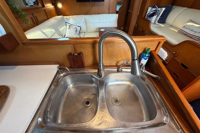 Slide: The Image of Interior of 1980 Amel Mango 52 yacht featuring a stainless steel sink and cozy seating area. - 42