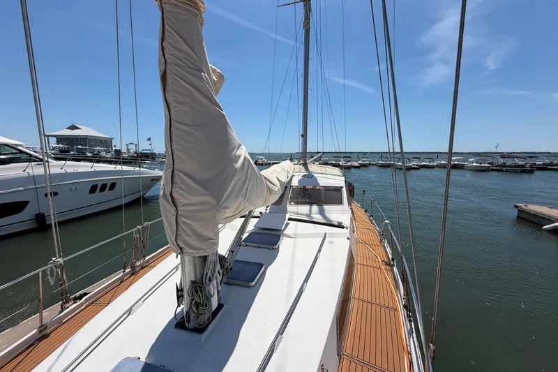 Slide: The Image of 1980 Amel Mango 52 sailboat docked at marina under clear blue sky. - 17