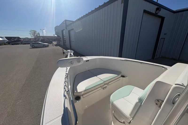 Slide: The Image of 2019 Robalo R180 Center Console boat parked near a warehouse under bright sunlight. - 13