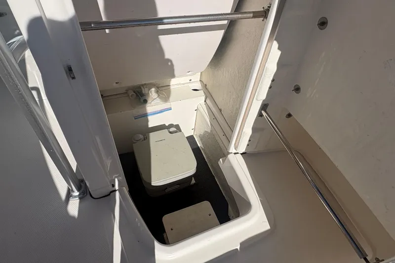 Slide: The Image of 2019 Robalo R180 Center Console boat interior with compact marine toilet. - 17