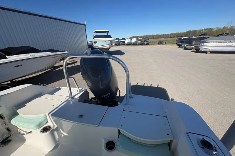 Slide: The Image of 2019 Robalo R180 Center Console boat with outboard motor in a marina storage area. - 5