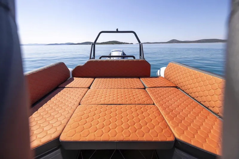 Slide: The Image of 2026 Highfield ADV7 boat with orange hexagonal-patterned seating, floating on calm blue waters. - 7