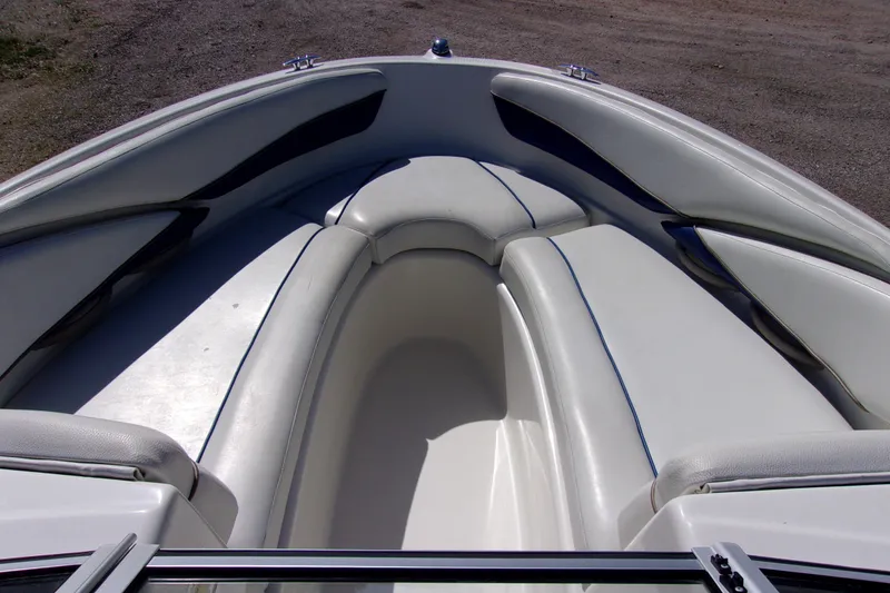 Slide: The Image of 2003 Bayliner 205 boat interior with white cushioned seating. - 11