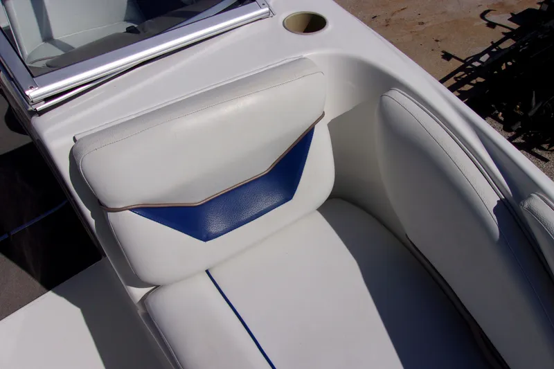 Slide: The Image of 2003 Bayliner 205 boat interior with white and blue seating, cup holder visible. - 12
