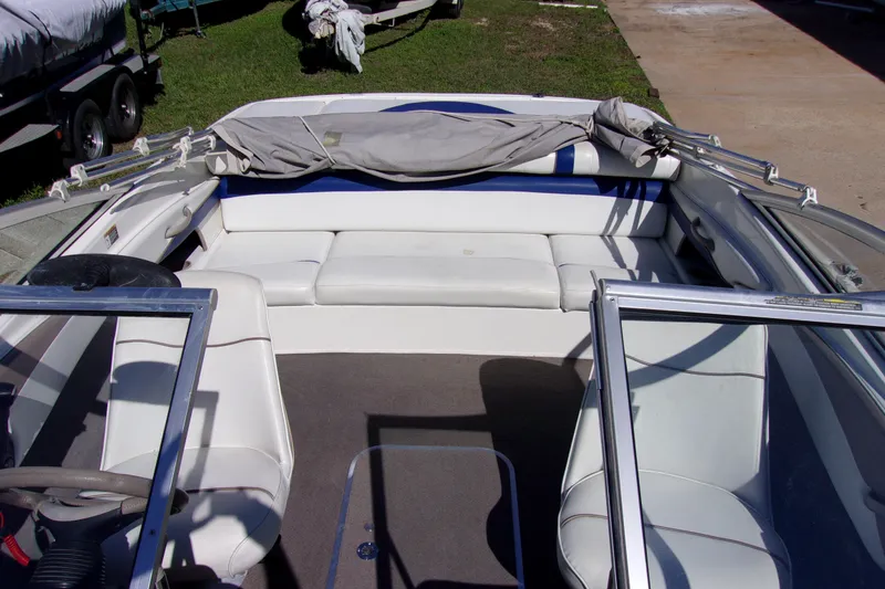 Slide: The Image of Interior of a 2003 Bayliner 205 boat with white seating and open windshield. - 14