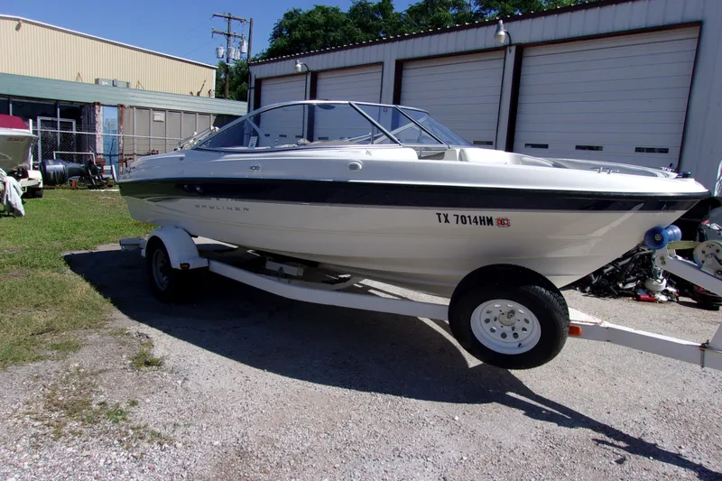 Slide: The Image of 2003 Bayliner 205 boat on trailer, parked outside a garage. - 2