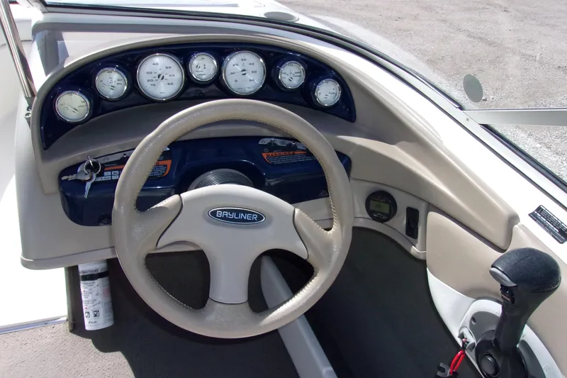 Slide: The Image of Dashboard of a 2003 Bayliner 205 boat with steering wheel and gauges. - 4