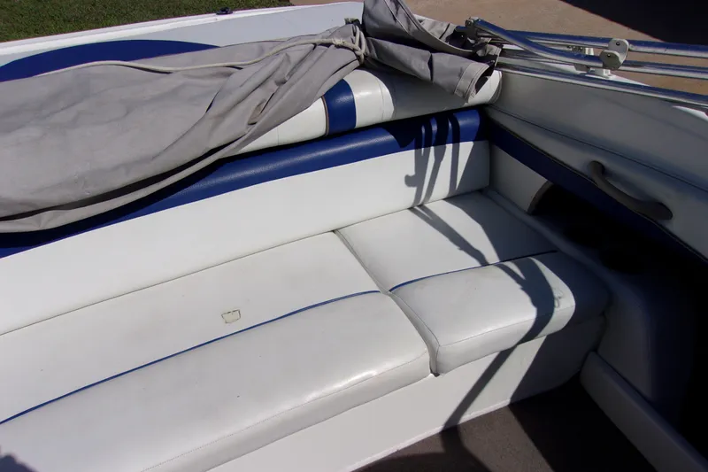 Slide: The Image of Interior seating of a 2003 Bayliner 205 boat with white and blue upholstery. - 8