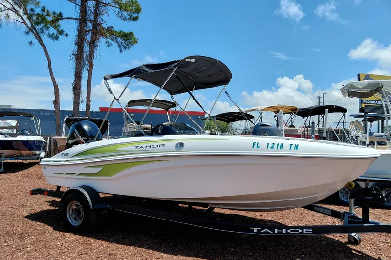 The Image of 2023 Tahoe T18 boat with canopy on trailer, displayed outdoors under clear sky. - 1