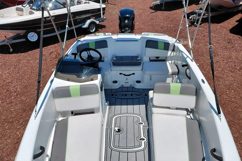 Slide: The Image of 2023 Tahoe T18 boat interior with seating and steering wheel, displayed outdoors. - 14
