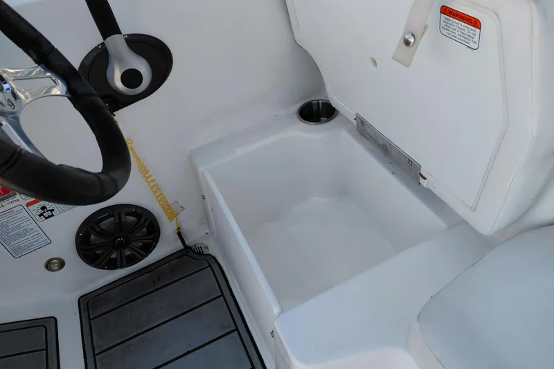 Slide: The Image of 2023 Tahoe T18 boat interior with steering wheel, speaker, and storage compartment. - 34