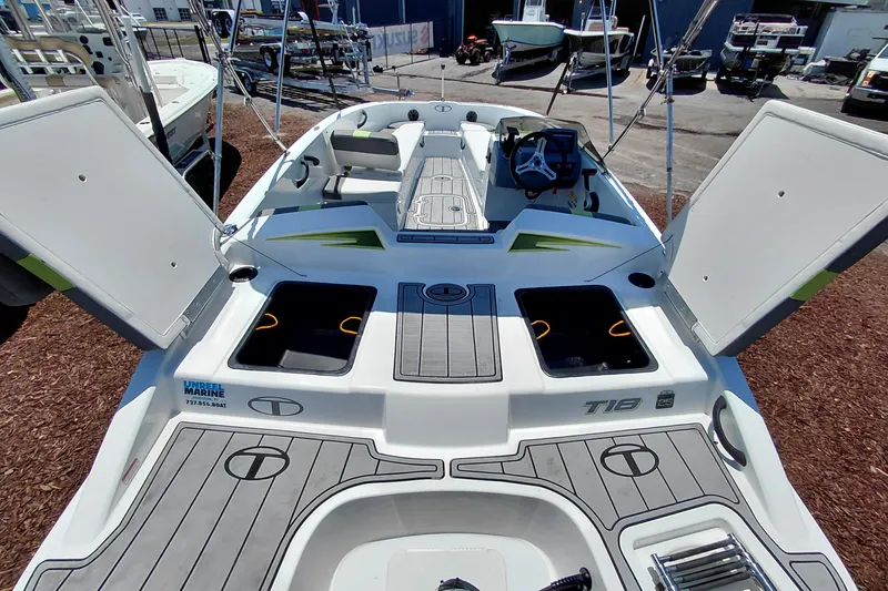Slide: The Image of 2023 Tahoe T18 boat interior with open storage compartments and steering wheel. - 42