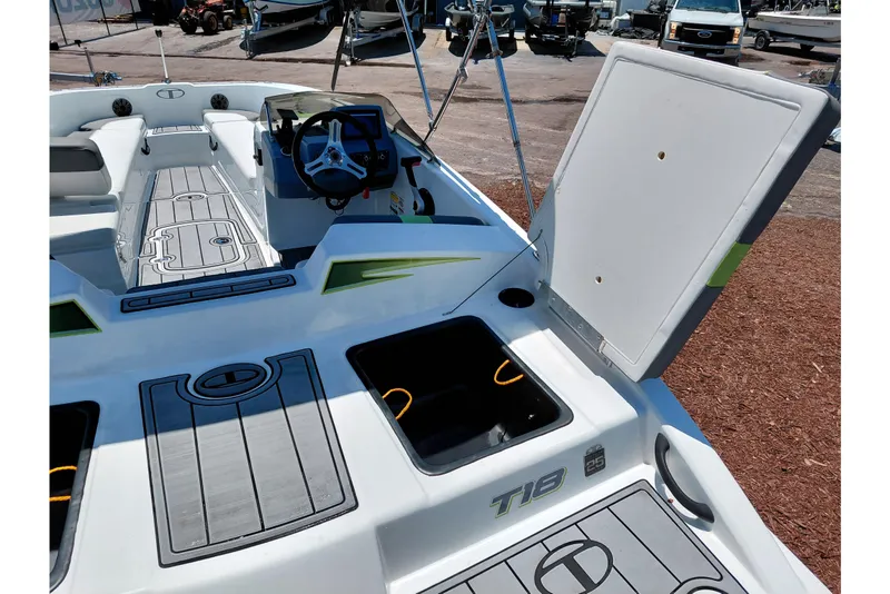 Slide: The Image of 2023 Tahoe T18 boat interior with open storage compartments and steering wheel. - 44