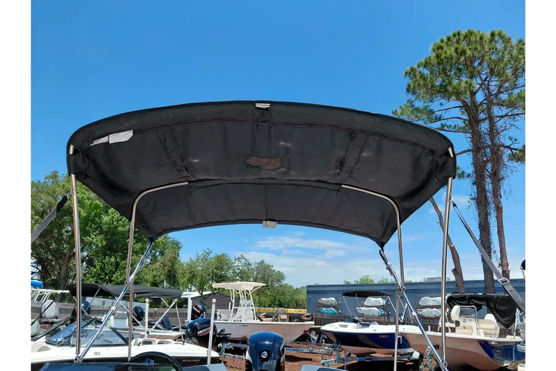 Slide: The Image of 2023 Tahoe T18 boat with black canopy in a sunny outdoor setting. - 47