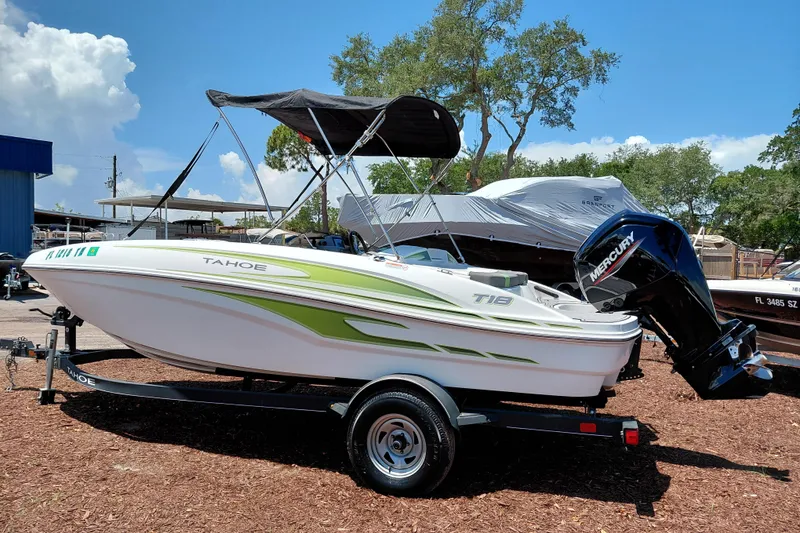 Slide: The Image of 2023 Tahoe T18 boat with Mercury engine on trailer, under clear blue sky. - 5