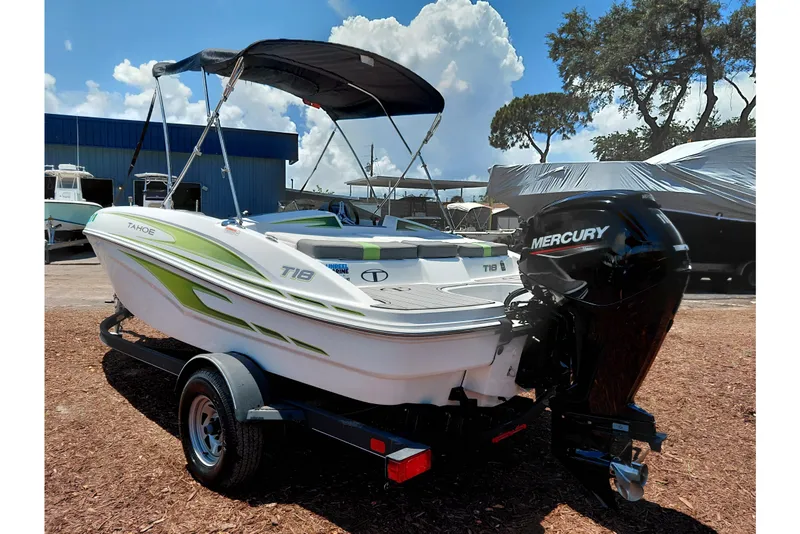 Slide: The Image of 2023 Tahoe T18 boat with Mercury engine on trailer, under a clear blue sky. - 50