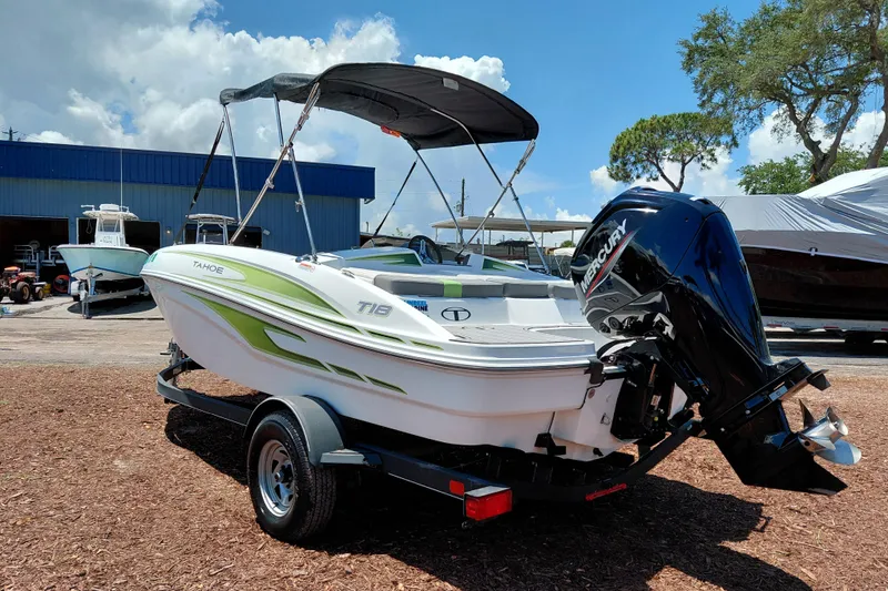 Slide: The Image of 2023 Tahoe T18 boat with Mercury outboard motor on trailer, parked outdoors. - 6