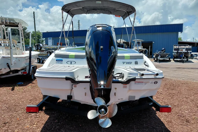 Slide: The Image of 2023 Tahoe T18 boat with outboard motor, displayed outdoors at a dealership. - 7
