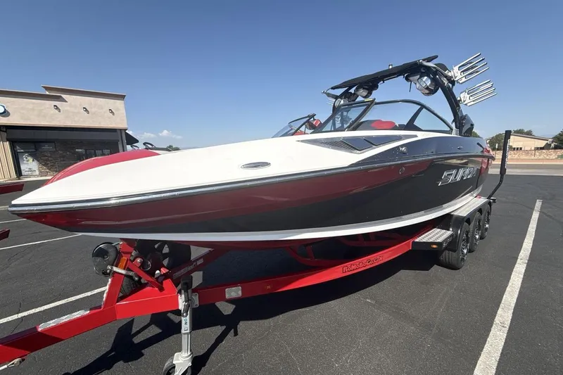 The Image of 2016 Supra SE 550 boat on trailer, parked outdoors under clear sky. - 1