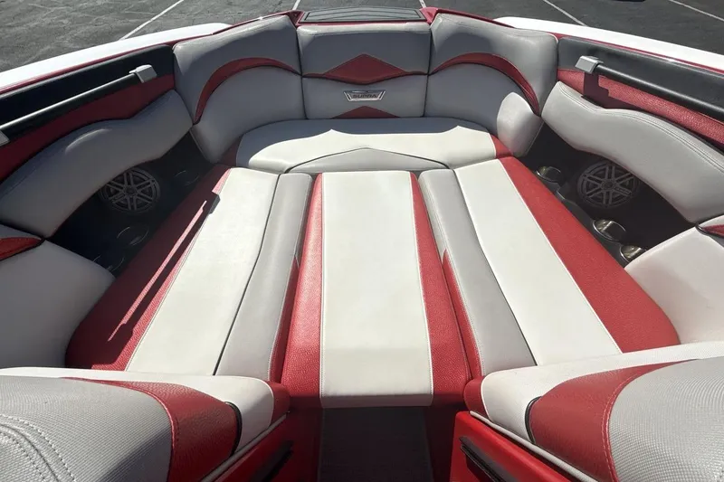 Slide: The Image of 2016 Supra SE 550 boat interior with red and white seating, cup holders, and speakers. - 11